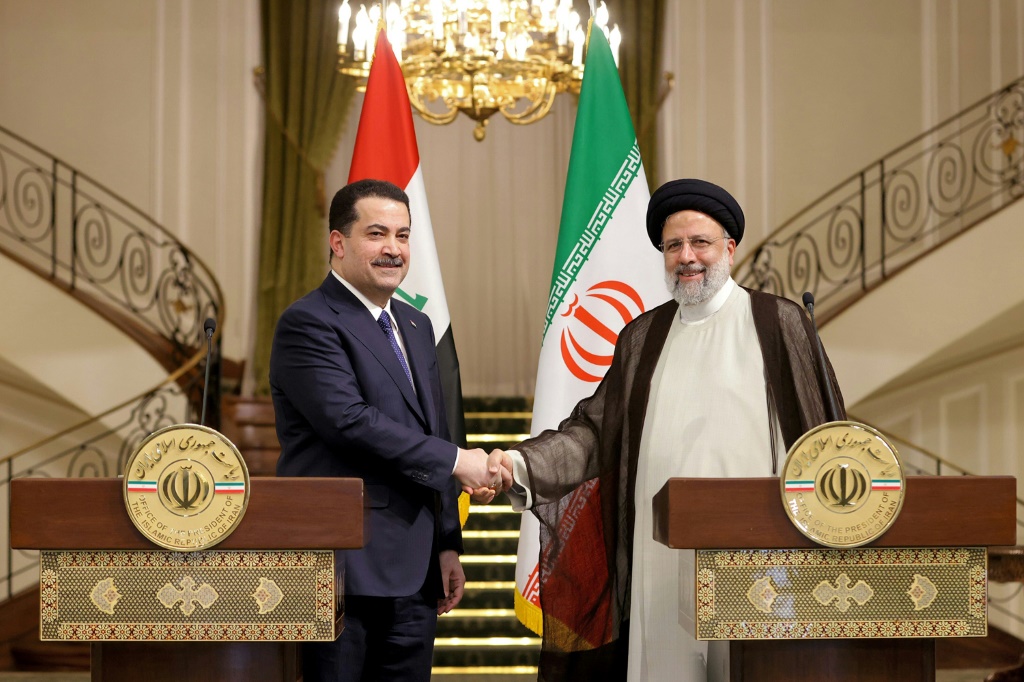 صورة وزّعتها الرئاسة الإيرانية تُظهر الرئيس الإيراني إبراهيم رئيسي ورئيس الوزراء العراقي محمد شياع السوداني وهما يتصافحان خلال مؤتمر صحافي مشترك في العاصمة الإيرانية طهران في 29 تشرين الثاني/نوفمبر 2022 (ا ف ب)
