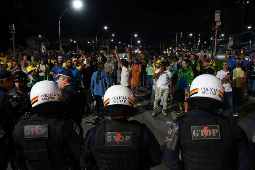 أنصار الرئيس جاير بولسونارو يواجهون الشرطة وهم يحتجون على اعتقال زعيم من السكان الأصليين في برازيليا في 12 ديسمبر 2022. (ا ف ب)   