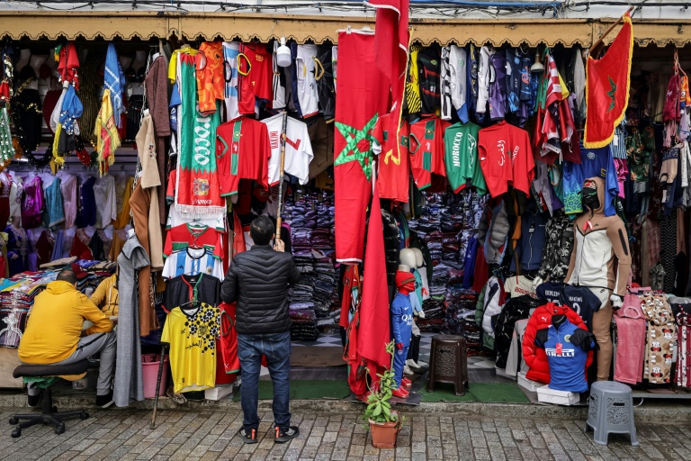 صاحب متجر لبيع الملابس الرياضية في العاصمة المغربية الرباط يوم 13 كانون الأول/ديسمبر 2022 قبل يوم من مباراة نصف نهائي مونديال قطر 2022 بين المغرب وفرنسا (أ ف ب)
