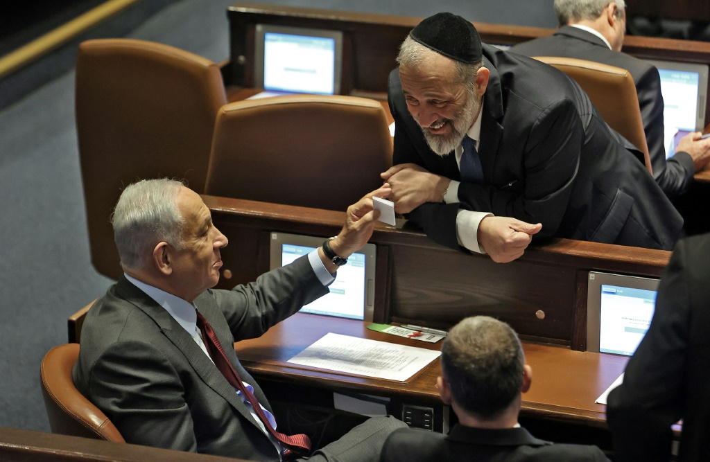 رئيس الوزراء الإسرائيلي المكلف بنيامين نتنياهو (إلى اليسار) يتحدث مع حليفه أرييه درعي من حزب شاس اليهودي المتطرف في الكنيست في 13 كانون الأول/ديسمبر 2022 (ا ف ب)