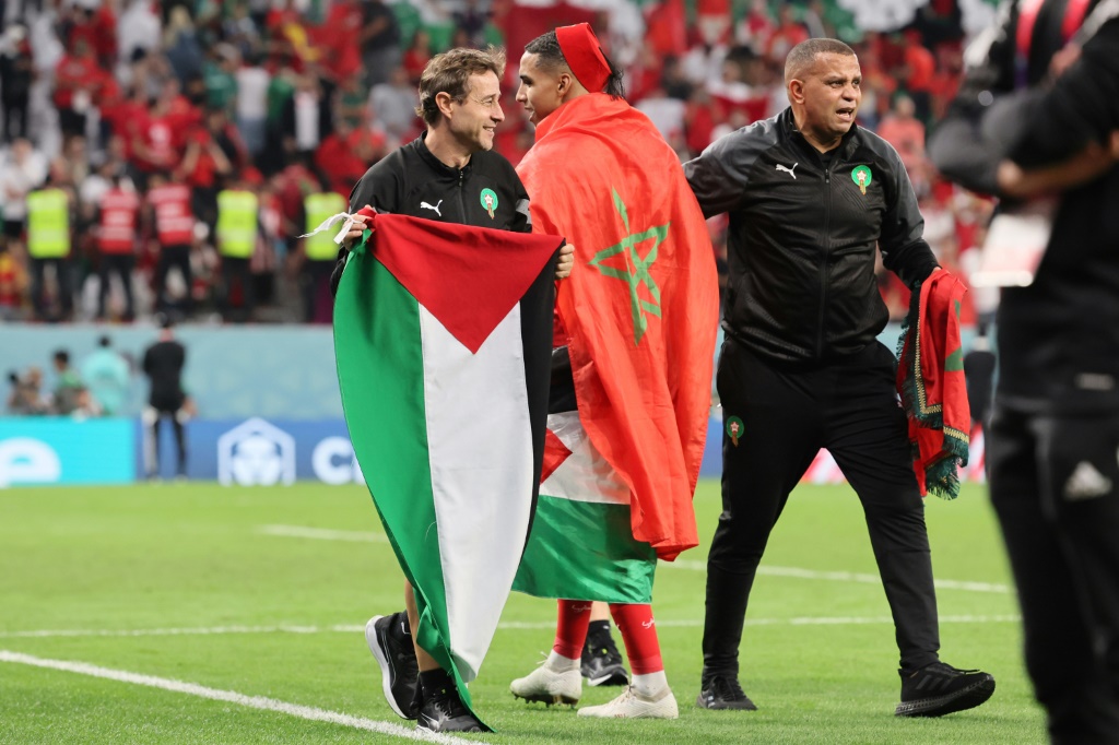    أحد أعضاء المنتخب المغربي يحمل العلم الفلسطيني بعد أن فاز الفريق بركلات الترجيح ليفوز بدوري كأس العالم لكرة القدم قطر 2022 بمباراة كرة القدم ضد إسبانيا يوم 6 ديسمبر 2022 (ا ف ب)   