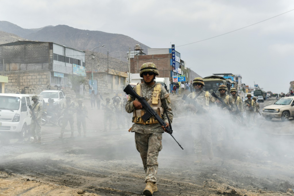 جنود بيروفيون يحرسون الكيلومتر السادس عشر من الطريق السريع الذي يربط اريكويبا ببونو في منطقة يورا في البيرو في 15 كانون الأول/ديسمبر 2022 (أ ف ب)