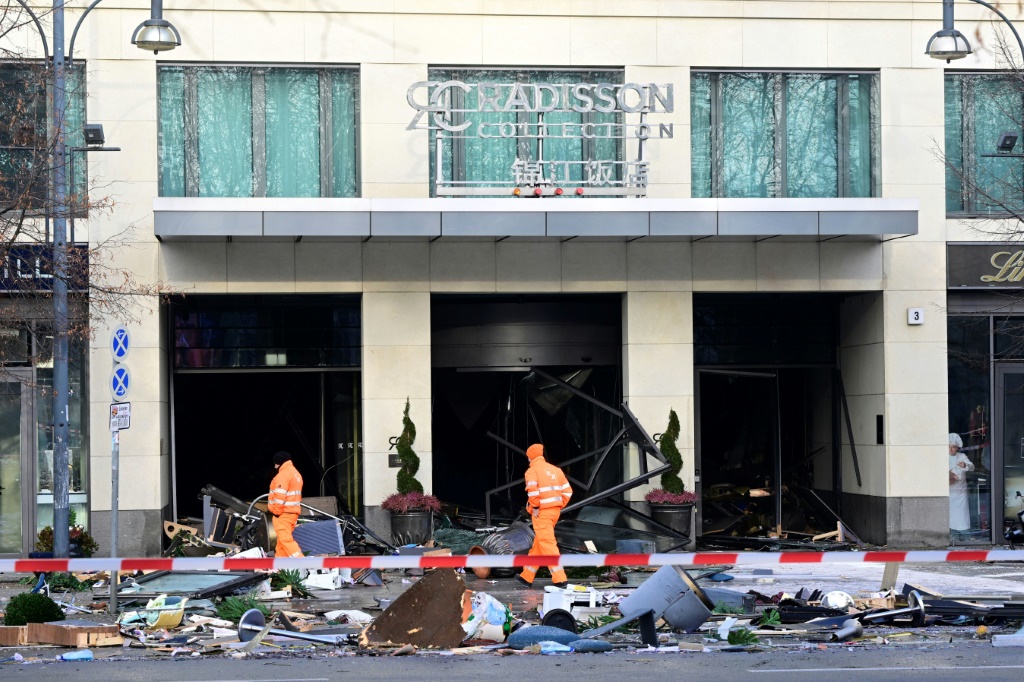 عمّال أمام فندق "ريديسون بلو" في لندن يتولون تنظيف مخلّفات انفجار حوض الأسماك بتاريخ 16 كانون الأول/ديسمبر 2022 (ا ف ب)