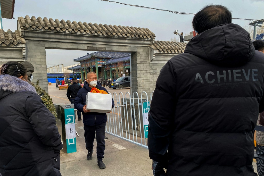 يحمل رماد قريب له أحرقت جثته في بكين في 20 كانون الأول/ديسمبر 2022 (ا ف ب)