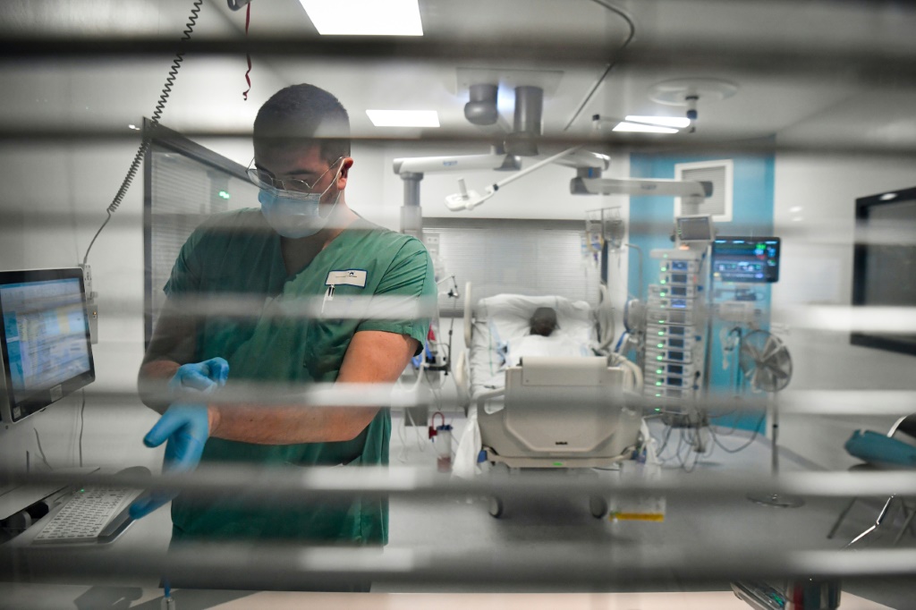 ممرّض مع مريض في إحدى غرف العناية الفائقة في مستشفى ديلافونتين في سان-دوني في ضاحية باريس في 29 كانون الأول/ديسمبر 2021 (ا ف ب)