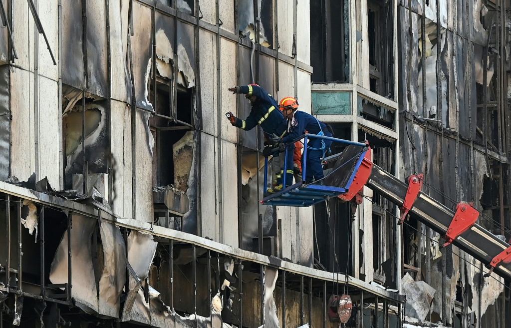 فريق إنقاذ يبحث عن ضحايا في جزء محترق من فندق وكازينو "غراند دايموند سيتي" بعد حريق كبير في المجمع الواقع في بويبت، في 30 كانون الأول/ديسمبر 2022 (ا ف ب)