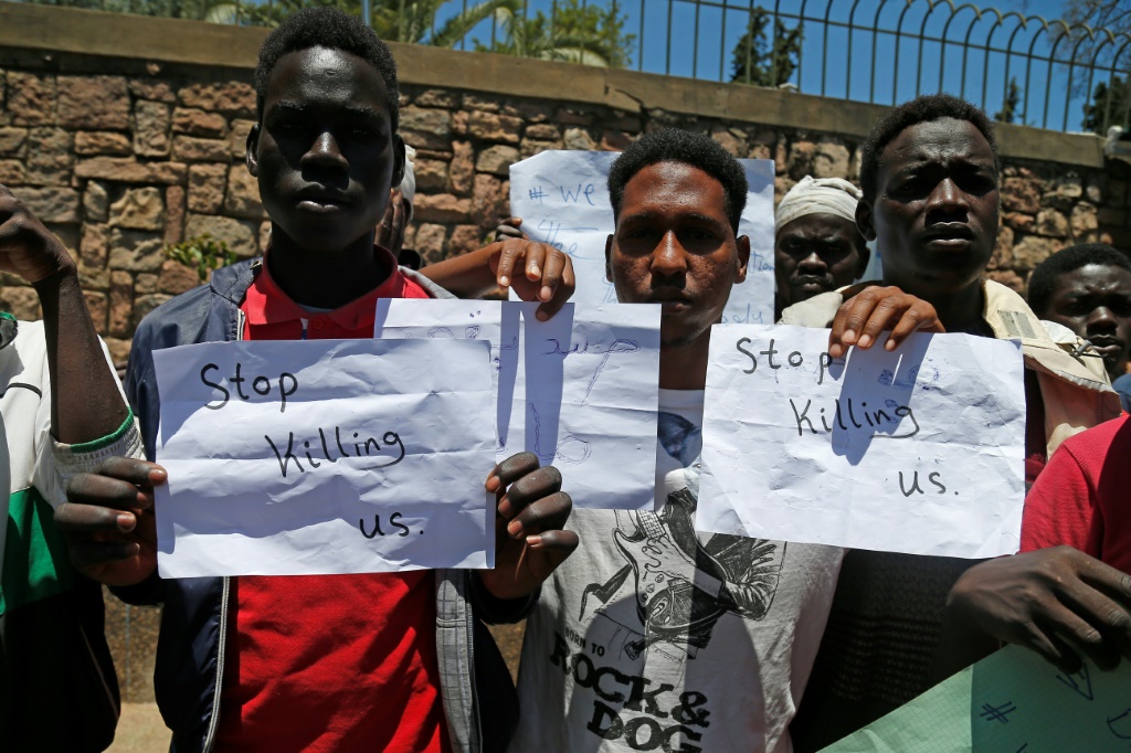 مهاجرون يحملون لافتات مكتوب عليها بالانكليزية "توقفوا عن قتلنا" في تظاهرة في الرباط في المغرب في 28 حزيران/يونيو 2022 (أ ف ب)