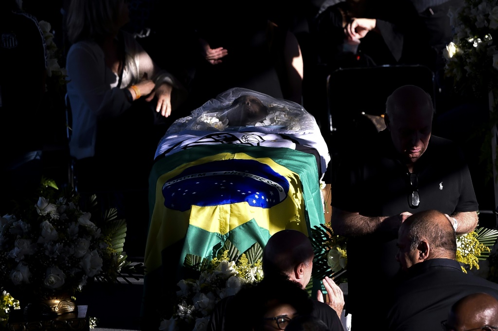 غطت أعلام البرازيل ونادي سانتوس نعش أسطورة كرة القدم البرازيلي بيليه أثناء الجنازة المفتوحة في سانتوس. (ا ف ب)