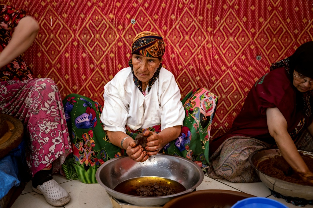 امرأة تعصر معجونا محضرا من الأرغان لاستخدامه في صنع زيت الأرغان، قرب الصويرة في جنوب المغرب في 15 تشرين الأول/أكتوبر 2022 (أ ف ب)