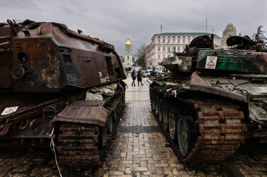 مارة قرب دبابات روسية مدمرة خلال معرض في الهواء الطلق في العاصمة الأوكرانية كييف (ا ف ب)