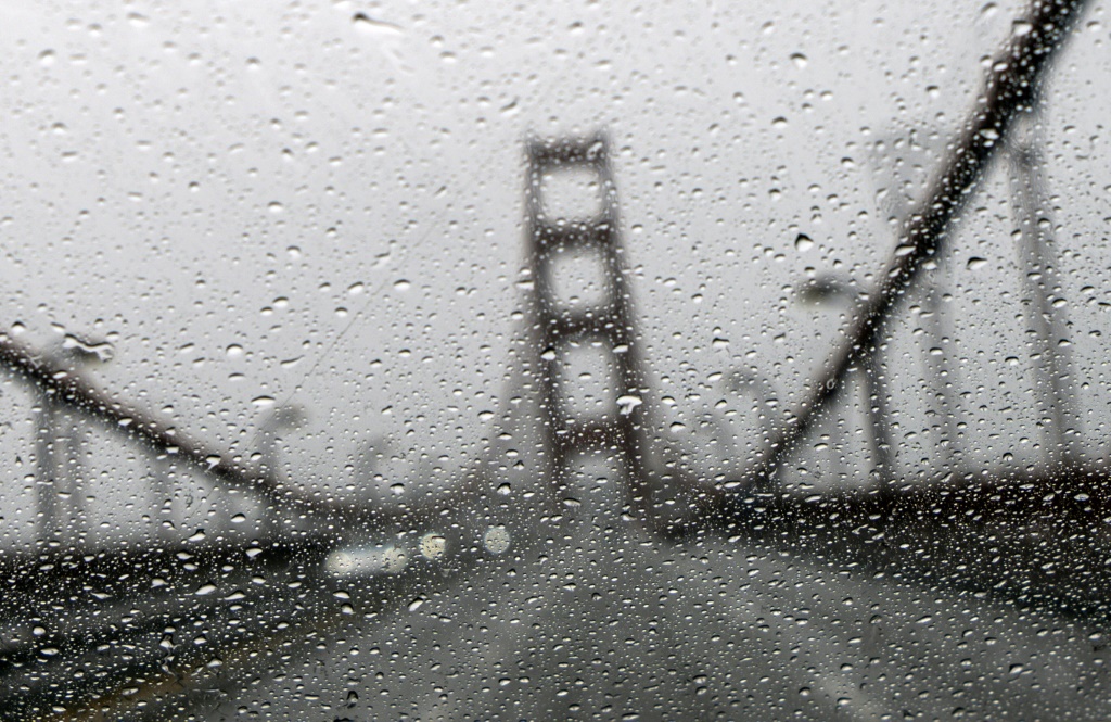 جسر غولدن غايت في صورة ملتقطة من وراء زجاج سيارة أمامي تغطيه الأمطار في سان فرانسيسكو في كاليفورنيا في الرابع من كانون الثاني/يناير 2023 (ا ف ب)
