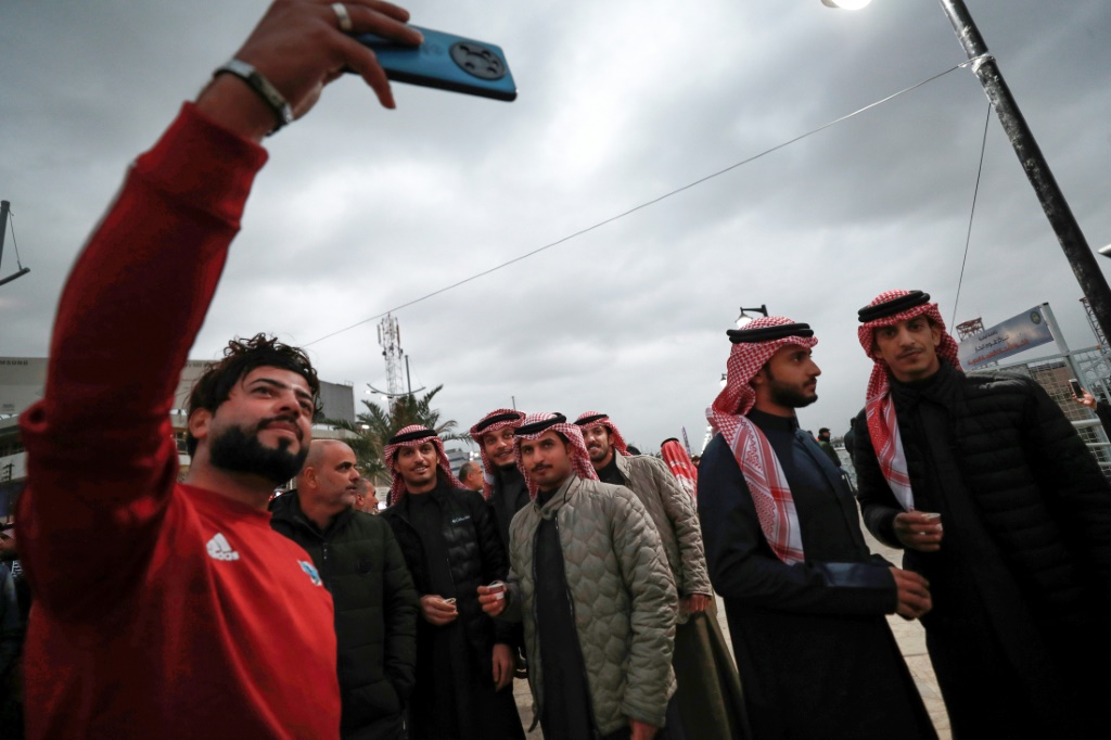 مشجعون يلتقطون الصور عشية انطلاق مباريات بطولة كأس الخليج في البصرة، في الخامس من كانون الثاني/يناير 2023 (ا ف ب)