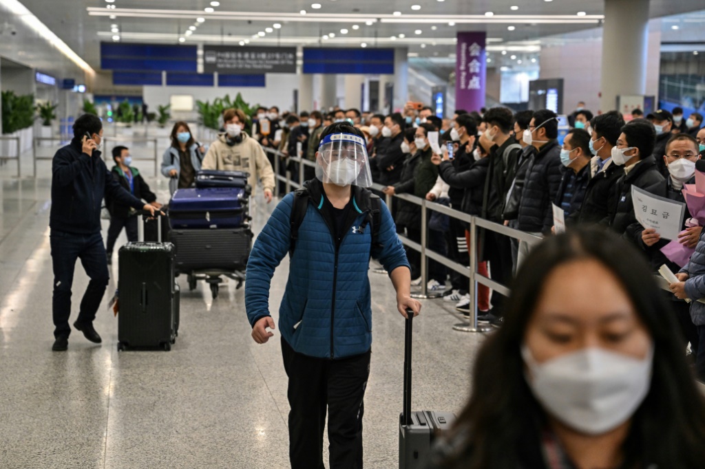 مسافرون في محطة وصول الرحلات الدولية في مطار بودونغ في شانغهاي في الثامن من كانون الثاني/يناير 2023 (ا ف ب)