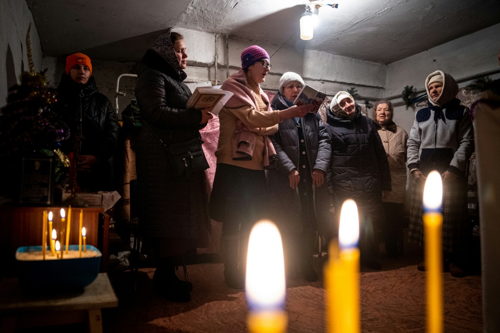 مؤمنون مسيحيون يصلون خلال قداس أرثوذكسي في ملجأ في تشاسيف يار في شرق أوكرانيا في 7 كانون الثاني/يناير 2023 (ا ف ب)