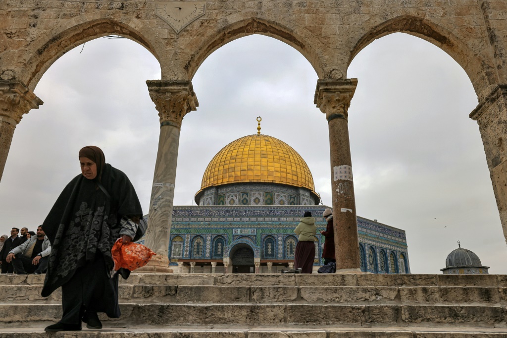 امرأة يظهر خلفها مسجد قبة الصخرة في الأقصى بتاريخ 3 كانون الثاني/يناير 2023 (ا ف ب)