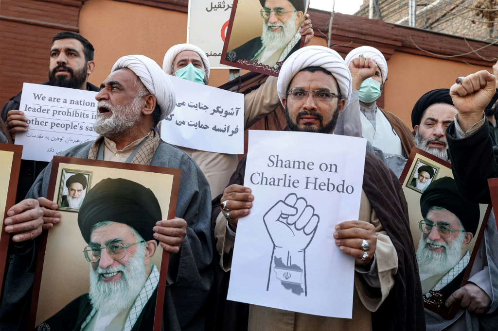 متظاهرون يرفعون صورا للمرشد الأعلى آية الله علي خامنئي خلال احتجاج أمام السفارة الفرنسية في طهران للتنديد برسوم شارلي إيبدو، الأحد 8 كانون الثاني/يناير 2023 (ا ف ب)