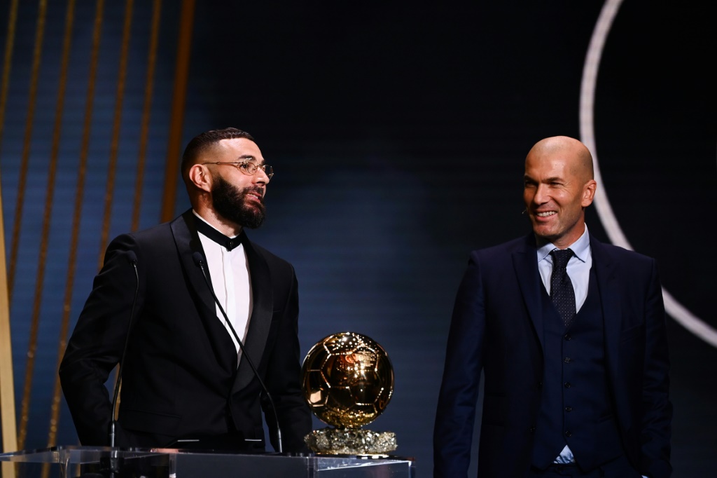 مهاجم ريال مدريد الفرنسي كريم بنزيمة (يسار) يتسلم الكرة الذهبية لافضل لاعب في العالم لعام 2022 من مواطنه زين الدين زيدان. 17 تشرين الاول/اكتوبر 2022 (ا ف ب)