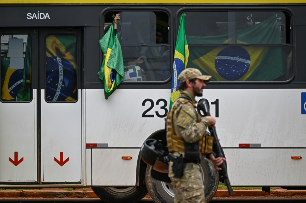 نقل موقوفين شاركوا في الهجوم في برازيليا الى مركز شرطة في 9 كانون الثاني/يناير 2023 (ا ف ب)  ا