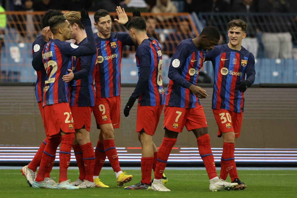 لاعبو برشلونة يحتفلون بافتتاح التسجيل في مرمى ريال بيتيس عبر المهاجم البولندي روبرت ليفاندوفسكي في نصف نهائي الكأس السوبر الاسبانية على ملعب الملك فهد في العاصمة السعودية الرياض في 12 كانون الثاني/يناير 2023 (ا ف ب)