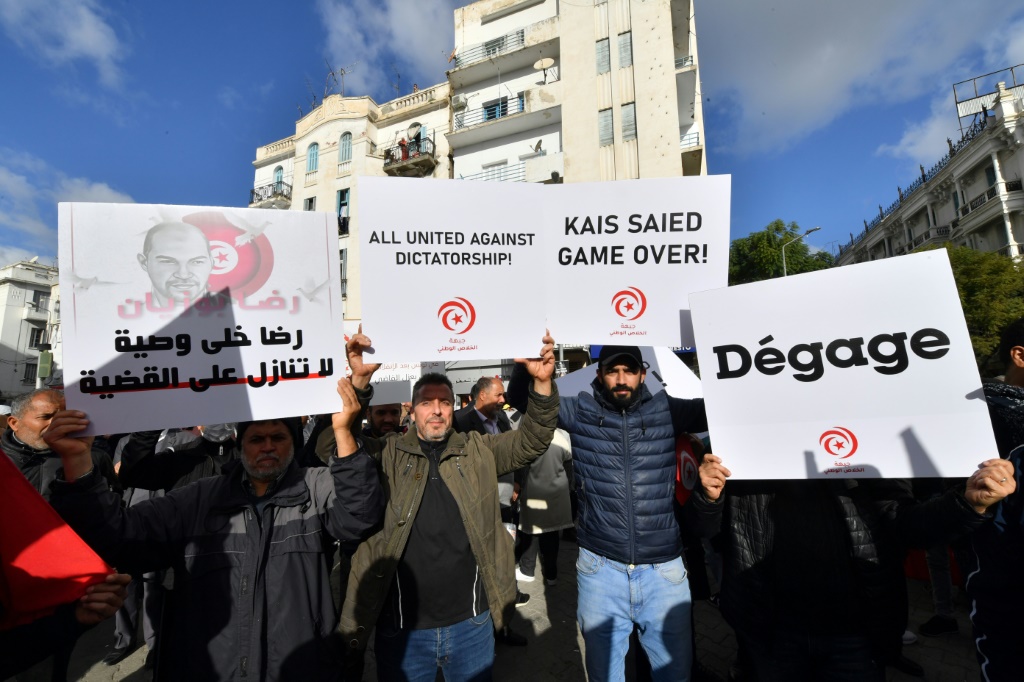 متظاهرون تونسيون يرفعون لافتات احتجاجية تطالب الرئيس بالتنحي أثناء نزولهم إلى شوارع العاصمة تونس (ا ف ب)