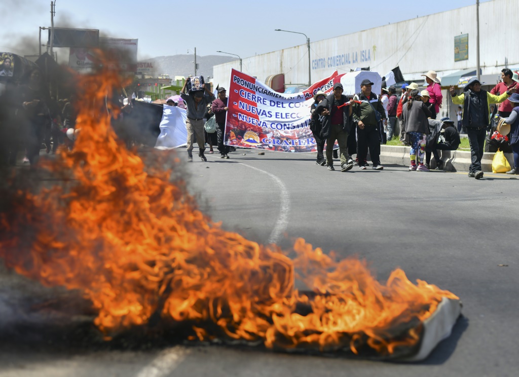 متظاهرون يقطعون طريقا في منطقة لا خويا بمقاطعة أريكيبا في جنوب البيرو للمطالبة باستقالة الرئيسة دينا بولوارتي في 12 كانون الثاني/يناير 2023 (ا ف ب)