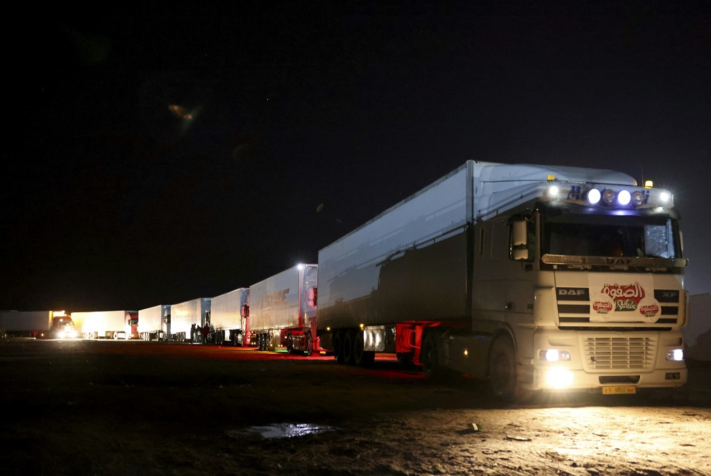 شاحنات ليبية تحمل منتجات غذائية مختلفة تمر عبر نقطة رأس جدير الحدودية مع تونس فجر يوم 17 كانون الثاني/يناير 2023 (ا ف ب)