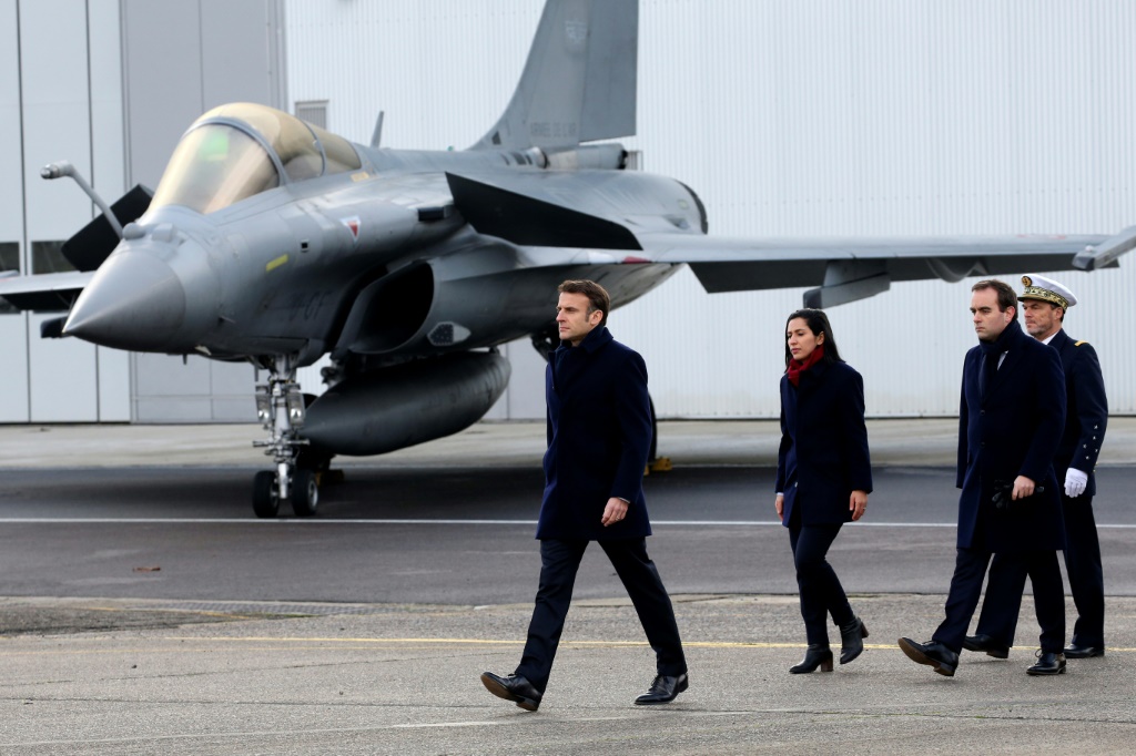 الرئيس الفرنسي إيمانويل ماكرون يسير بجوار طائرة مقاتلة من طراز داسو رافال في قاعدة مون دو مارسان الجوية، جنوب غرب فرنسا، في 20 كانون الثاني/يناير 2023 (ا ف ب)