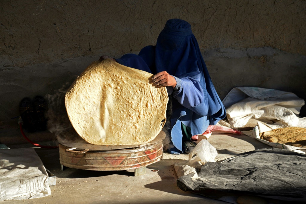 امرأة أفغانية تعدّ خبزا لبيعه في سوق في قندهار في الخامس من كانون الثاني/يناير 2023 (ا ف ب)