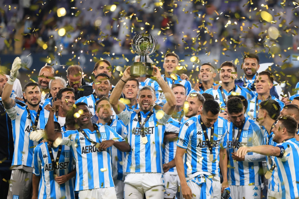 لاعبو راسينغ كلوب يحتفلون بالفوز بلقب النسخة الاولى من الكأس السوبر الارجنتينية الدولية لكرة القدم بعد الفوز القاتل على بوكا جونيورز 2-1 في استاد هزاع بن زايد في مدينة العين الاماراتية في أبوظبي في 20 كانون الثاني/يناير 2023 (ا ف ب)