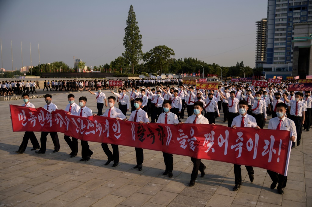    طلاب كوريون شماليون يشاركون في مسيرة رافعين لافتة كتب عليها "مزقوا المنشقين من الشمال الذين يخونون الأمة والحثالة البشرية!" وهم يسيرون في بيونغ يانغ في حزيران (يونيو) 2020 (ا ف ب)