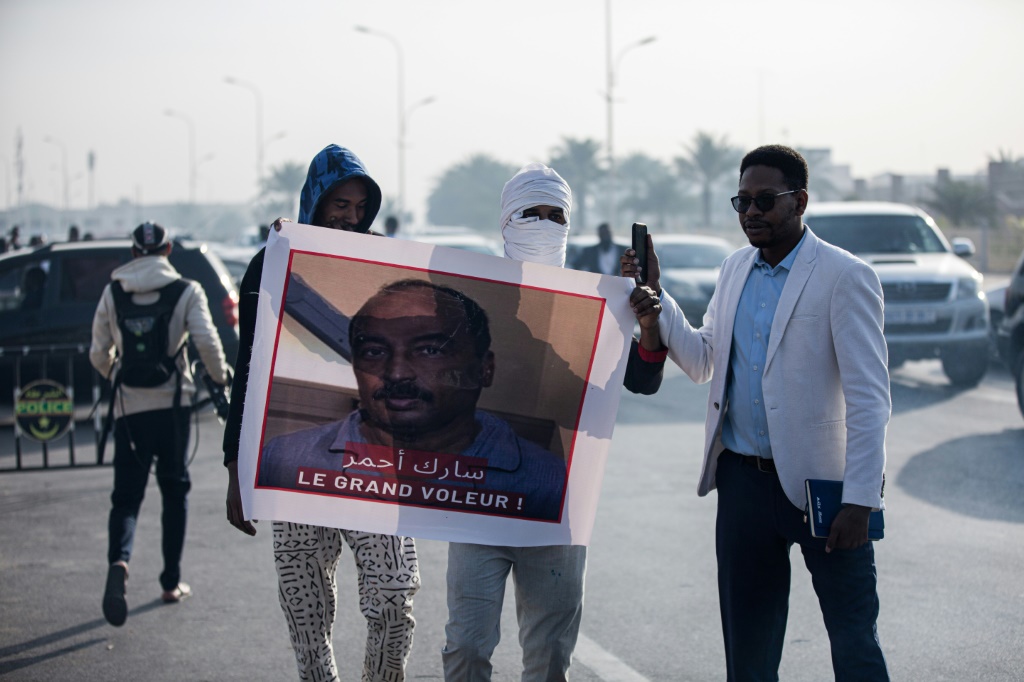 متظاهرون موريتانيون يرفعون لافتة ضد الرئيس السابق محمد ولد عبد العزيز مع بدء محاكمته بتهم فساد في نواكشوط في كانون الثاني/يناير 2023 (ا ف ب)