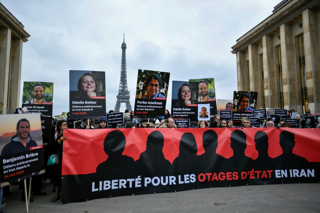    متظاهرون يرفعون صور الفرنسيين المحتجزين في إيران خلال تجمّع في باريس بتاريخ 28 كانون الثاني/يناير 2023 (ا ف ب)