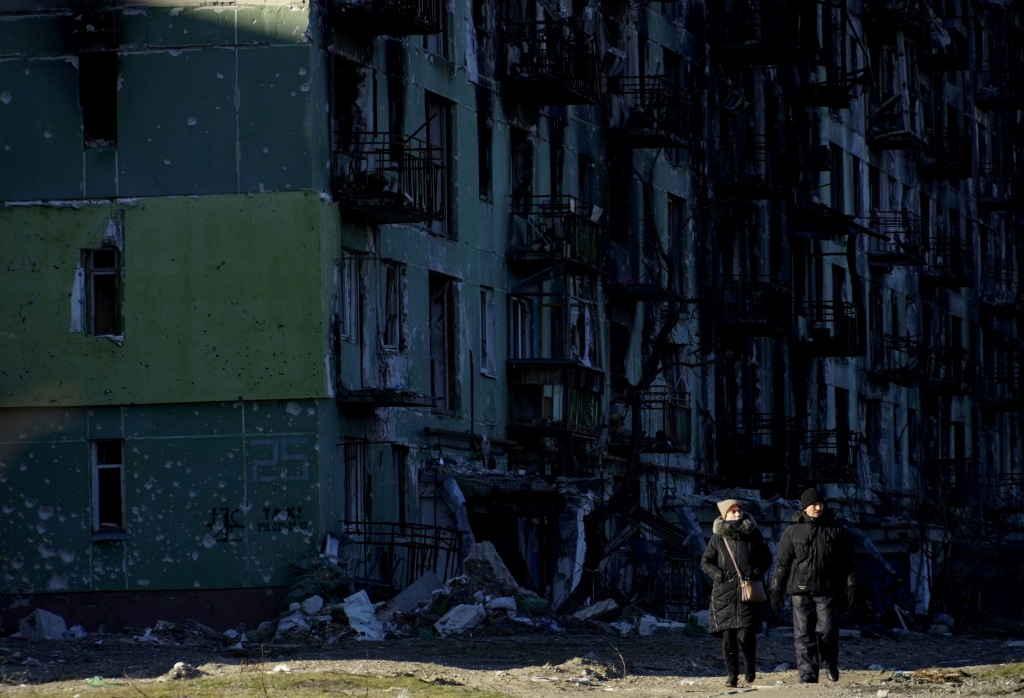 شخصان يمشيان قرب مبنى سكني مدمّر في بلدة سيفيرودونيتسك الخاضعة لسيطرة أوكرانية في منطقة لوغانسك بشرق أوكرانيا في 24 كانون الثاني/يناير 2023 (ا ف ب)