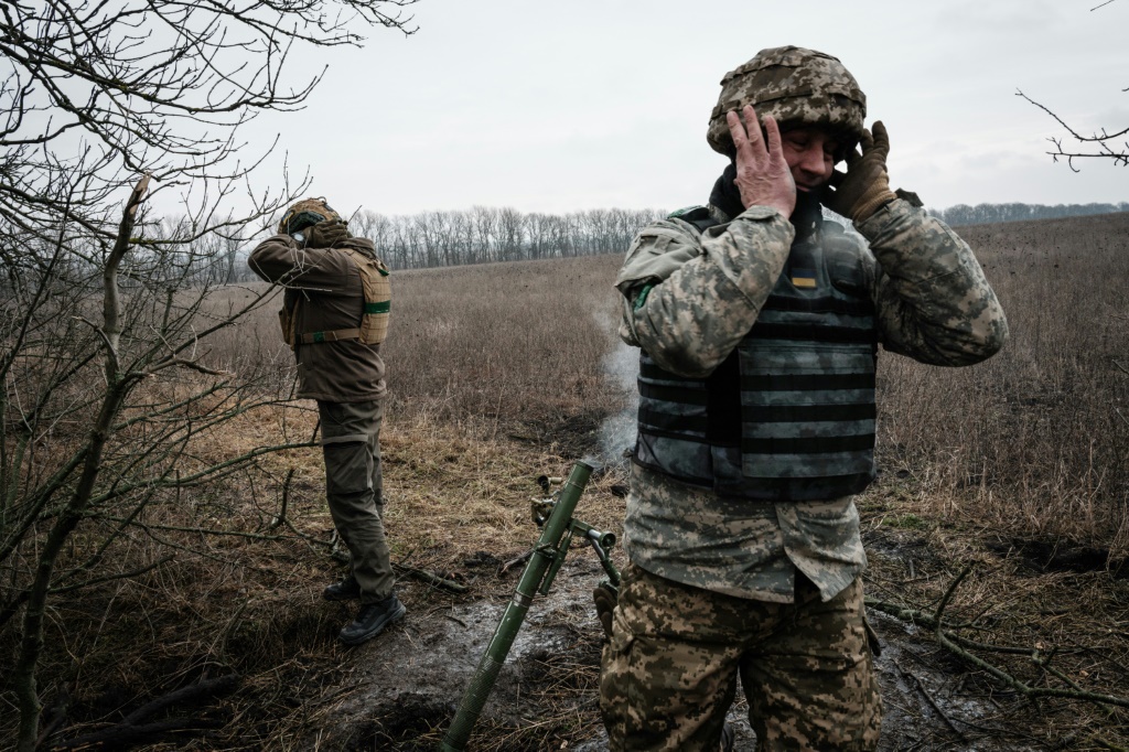 جنديان أوكرانيان يصمّان آذانهما بعد ضربهما مواقع روسية قرب خط الجبهة في منطقة دونيتسك في 31 كانون الثاني/يناير 2023 (ا ف ب)   