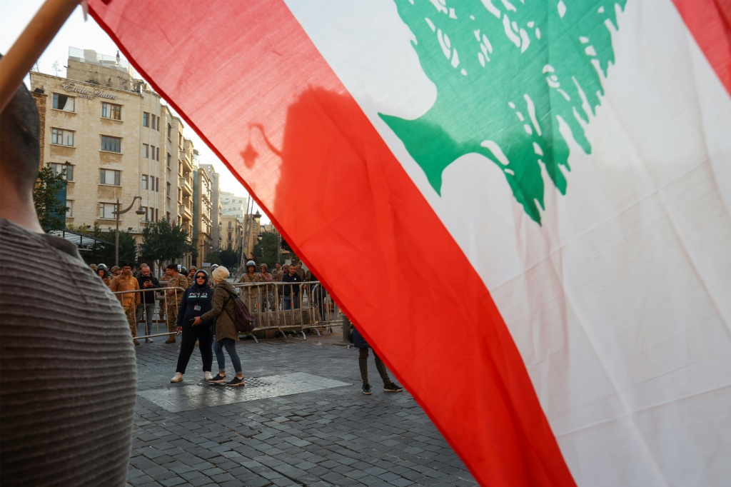     شاب يرفع العلم اللبناني خلال تظاهرة في بيروت في 20 كانون الثاني/يناير 2023 (ا ف ب)