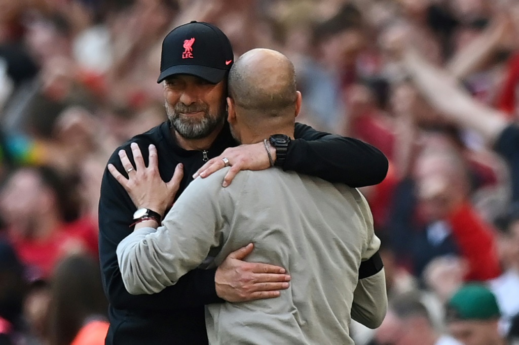 عناق بين مدرب ليفربول الالماني يورغن كلوب (يسار) ومدرب مانشستر سيتي الاسباني بيب غوارديولا في نهاية مباراة الدور نصف النهائي من كأس انكلترا لكرة القدم. 16 نيسان/ابريل 2022 (ا ف ب)