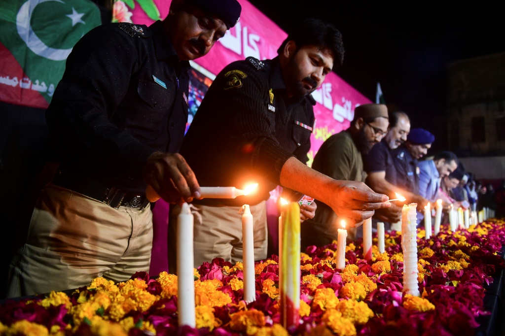    ضباط الشرطة وسكان كراتشي يحيون ضحايا التفجير الانتحاري الذي وقع يوم الاثنين في مسجد في بيشاور (أ ف ب)
