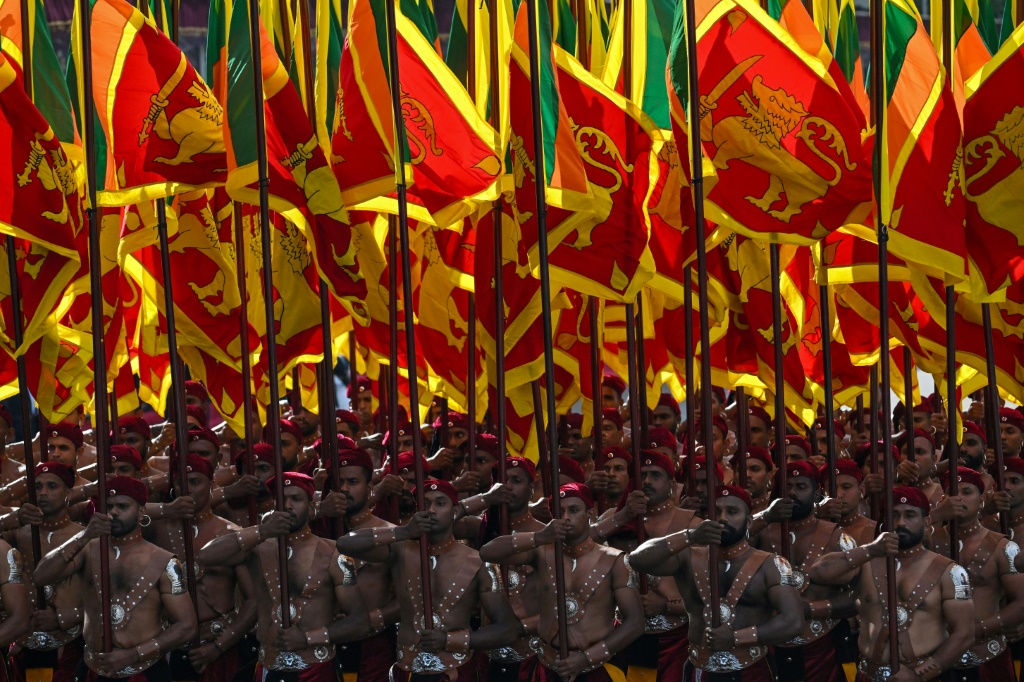 جنود سريلانكيون يحملون علم بلدهم خلال مراسم الاحتفال بالذكرى الـ75 على استقلاله في كولومبو في الرابع من شباط/فبراير 2023 (ا ف ب)