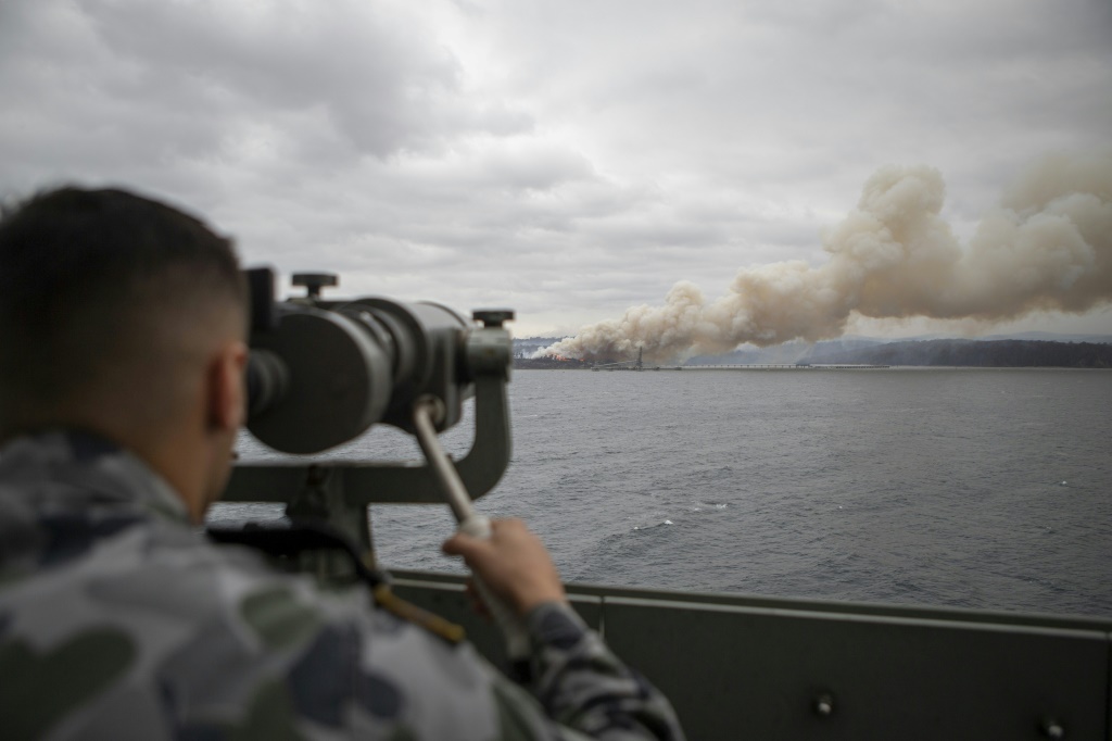 صورة نشرتها وزارة الدفاع الأسترالية في 6 كانون الثاني/يناير تظهر جنديا في البحرية يراقب بالمنظار دخان حريق في نيو ساوث ويلز (ا ف ب)