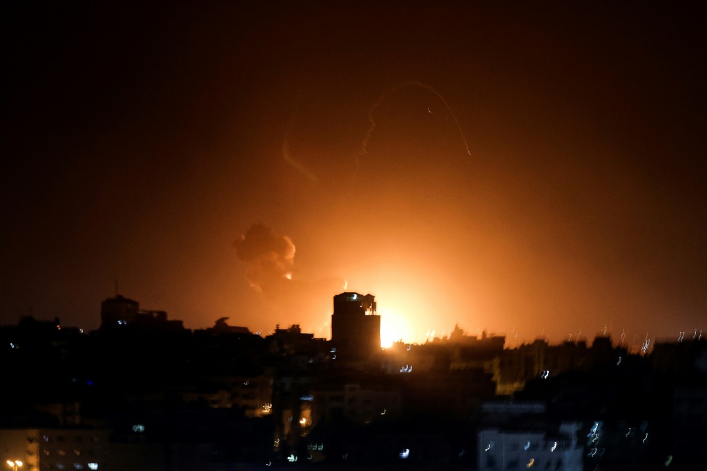 النار والدخان يتصاعدان فوق المباني في مدينة غزة حيث شنت إسرائيل غارات جوية على القطاع الفلسطيني في وقت مبكر من الثاني من شباط/فبراير 2023 (ا ف ب)
