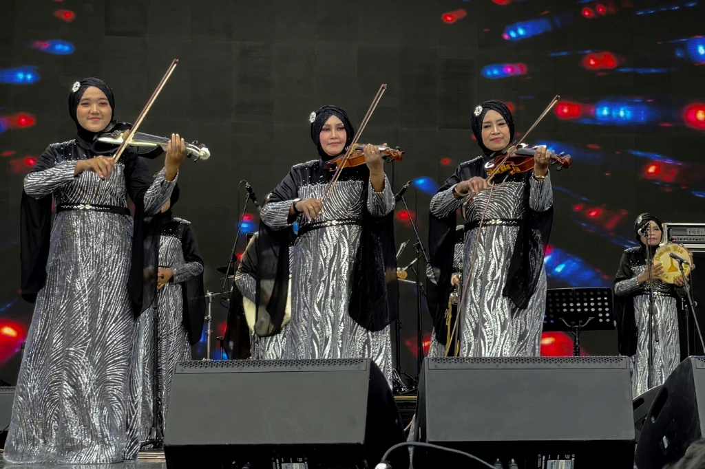 صورة التقطت في 6 كانون الثاني/يناير 2023 خلال مهرجان في العاصمة الإندونيسية جاكرتا لعازفات فرقة "ناسيدا ريا" اللواتي يرندين فساتين فضية ويضعن الحجاب (ا ف ب)