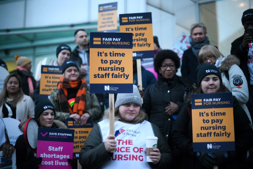    ممرضات وممرضين مضربين عن العمل يحملون لافتات عند نقطة اعتصام خارج مستشفى يونيفرسيتي كوليدج في لندن في 19 كانون الثاني/يناير 2023 (ا ف ب)