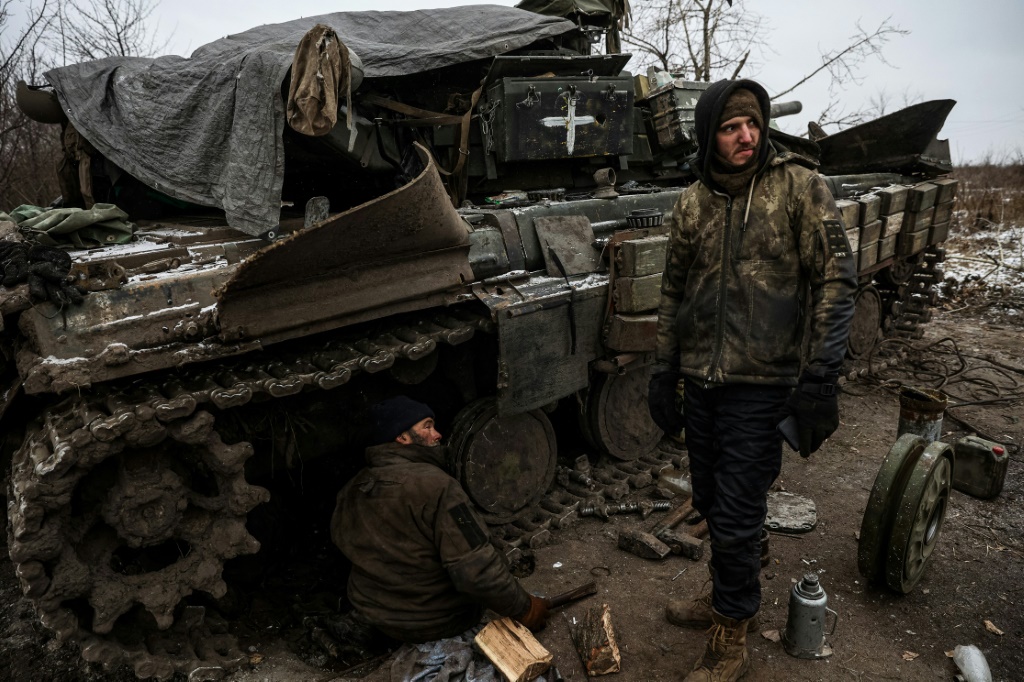 جنود اوكرانيون يصلحون دبابة على خط الجبهة في منطقة لوغانسك في 12 كانون الثاني/يناير 2023 (أ ف ب)