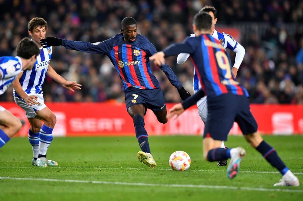 مهاجم برشلونة الفرنسي عثمان ديمبيليه (في الوسط) يركل الكرة خلال مباراة ربع نهائي كأس ملك اسبانيا لكرة القدم امام ريال سوسيداد، على ملعب كامب نو في 25 كانون الثاني/يناير 2023 (ا ف ب)