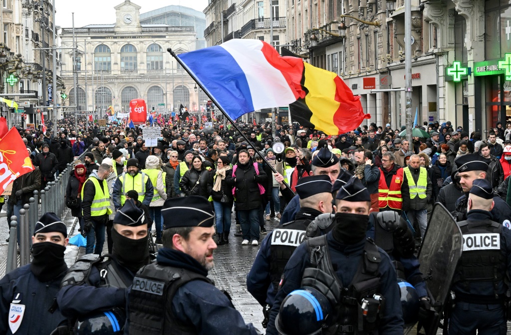 عناصر من الشرطة إلى جانب محتجين أثناء تظاهرة ضد إصلاح نظام التقاعد في مدينة ليل في شمال فرنسا في 31 كانون الثاني/يناير 2023 (ا ف ب)