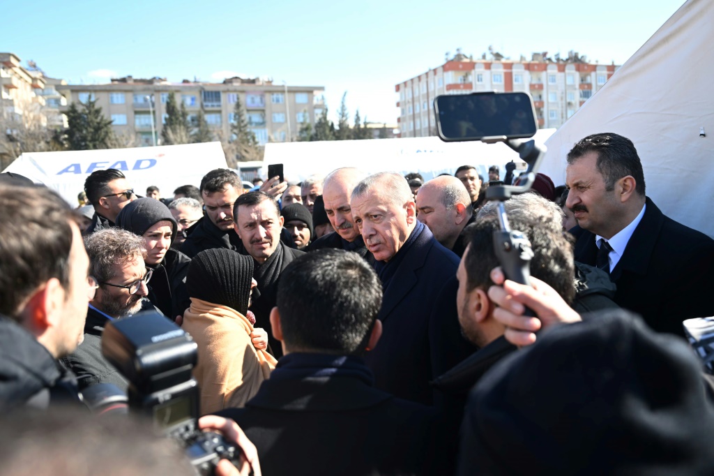 الرئيس التركي رجب طيب إردوغان يلتقي منكوبين لجأوا إلى خيم أقامتها الحكومة، خلال زيارته مدينة كهرمان مرعش بجنوب البلاد في 8 شباط/فبراير 2023 بعد يومين على الزلزال الذي ضرب جنوب شرق البلاد (أ ف ب)
