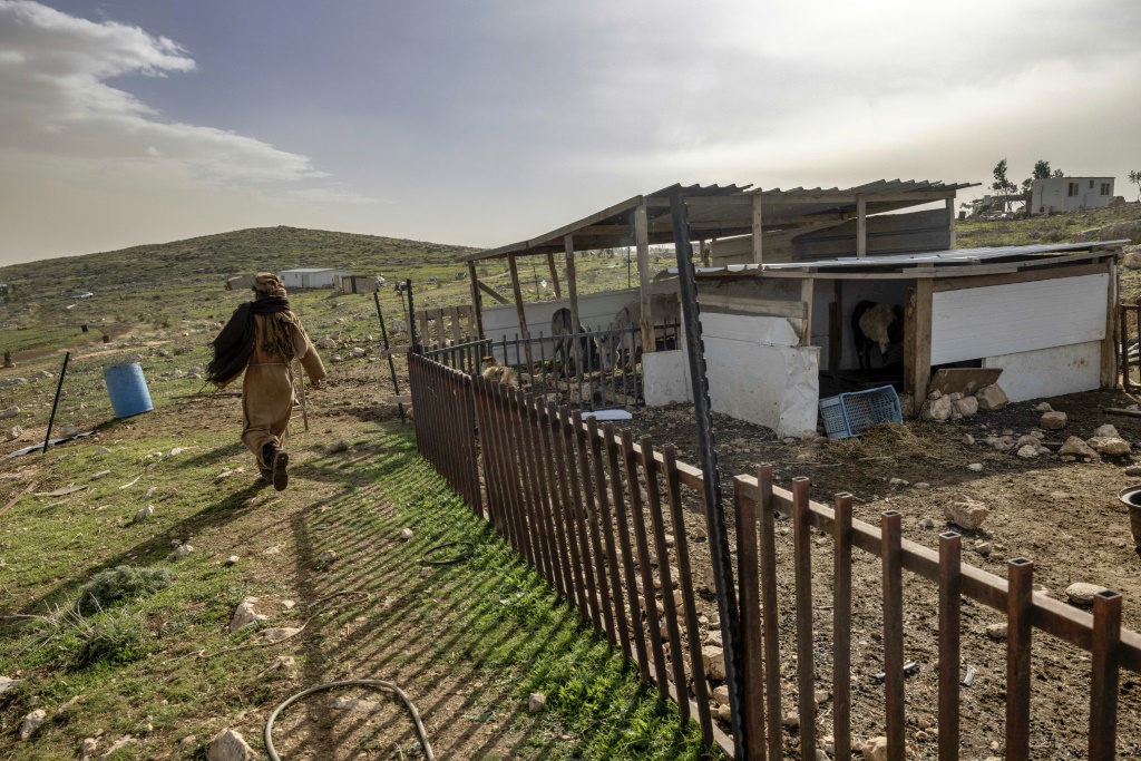 رجل يسير في مستوطنة عشوائية في الأول من شباط/فبراير 2023 تم بناؤها دون إذن من الحكومة الإسرائيلية في الضفة الغربية المحتلة (ا ف ب)