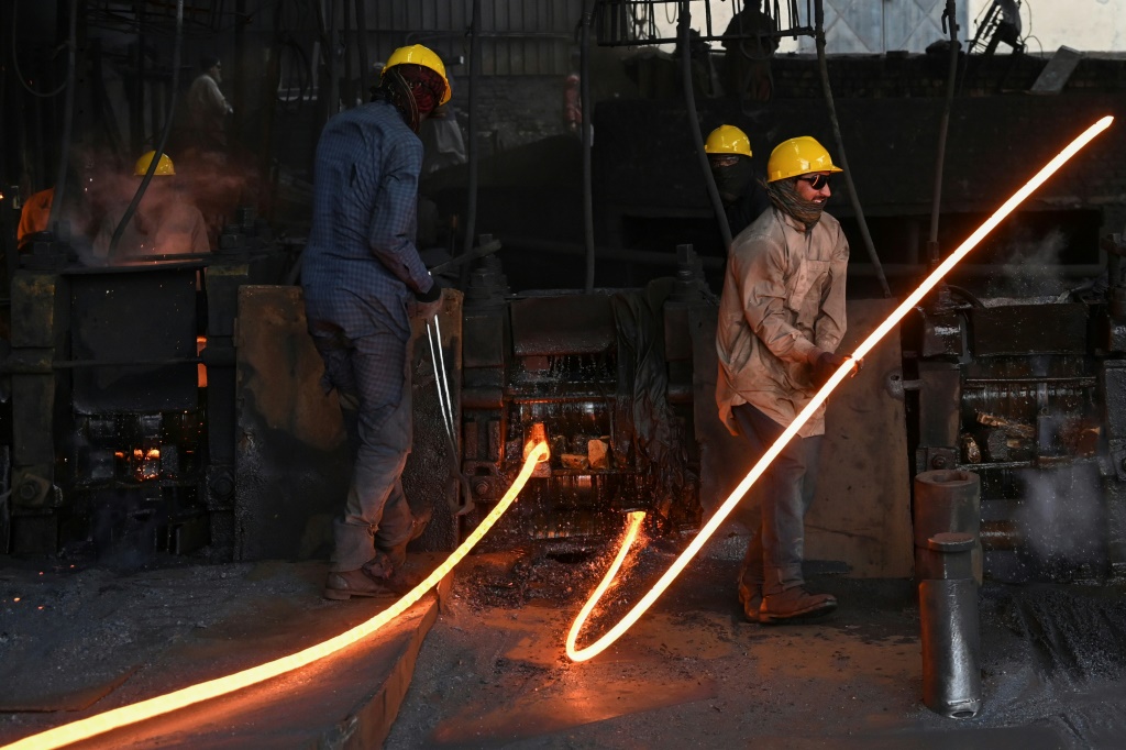    عمال يصببون قضبان فولاذية منصهرة في مصنع في إسلام أباد (أ ف ب)