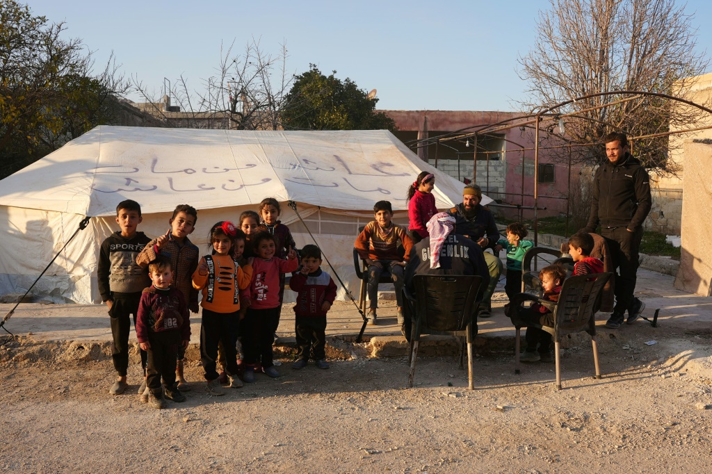    عائلة سورية أمام الخيمة التي تقطن فيها منذ الزلزال في جنديرس في سوريا في 14 شباط/فبراير 2023 (ا ف ب)