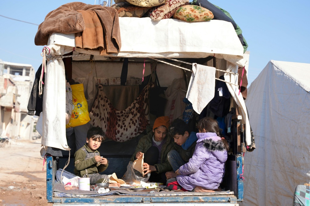    عائلات سوريين نازحين بسبب الزلزال في جنديرس في سوريا في 12 شباط/فبراير 2023 (ا ف ب)